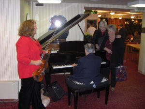 Karen Frink and Shar Roge sing Christmas carols accompanied by the John Stone Duo.